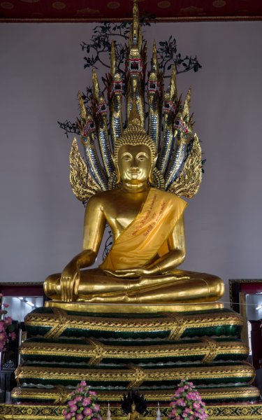 Le plus grand Bouddha assis sur un serpent enroulé couvert d'émail verte. Derrière lui les 7 têtes du serpent se dressent au dessus de sa tête.