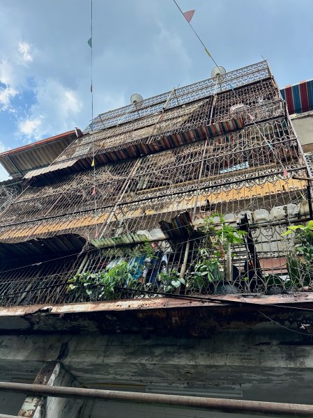 Une maison à deux étages dont la façade est entièrement grillagée.