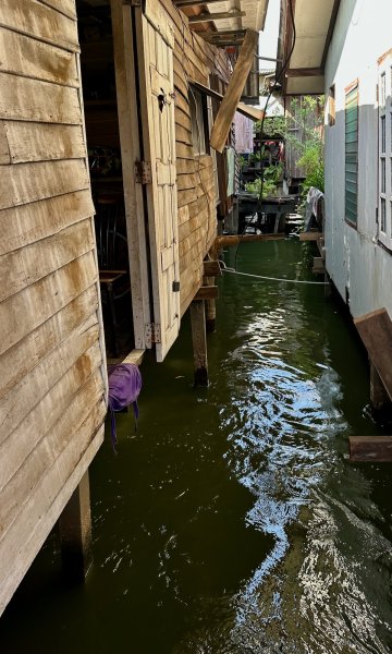 L'eau du canal entre deux maisons en bois sur pilotis.