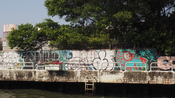 Un mur bordant le canal avec des graffitis.