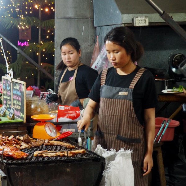 deux jeunes femmes font des grillades pour les vendre dans la rue principale
