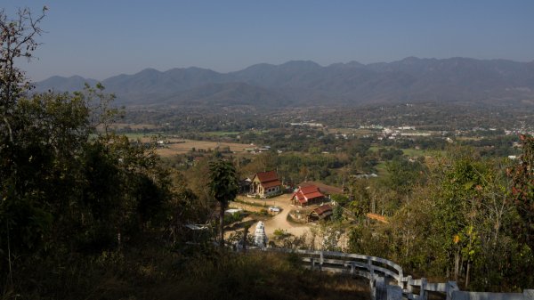 La vallée avec les montagne autour et deux bâtiments traditionnel aux toits de brique vues depuis l'esplanade du bouddha.
