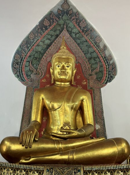Un grand Bouddha assis dans une salle qui lui est réservée