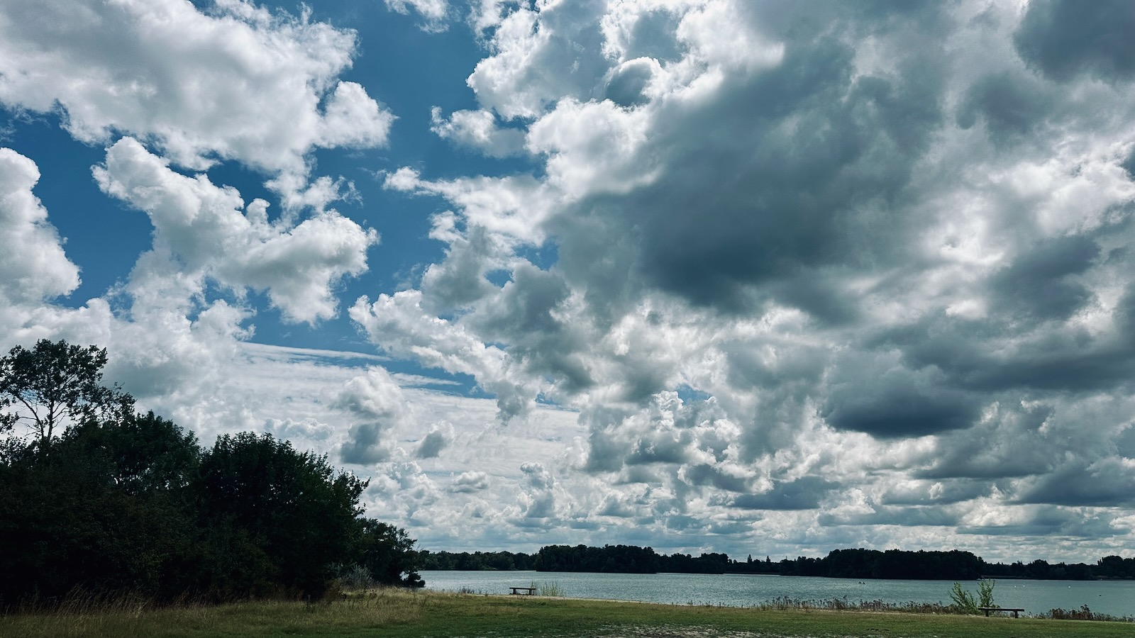 Un ciel très nuageux, de gros nuages blancs au dessus du lac. photographie au grand angle.