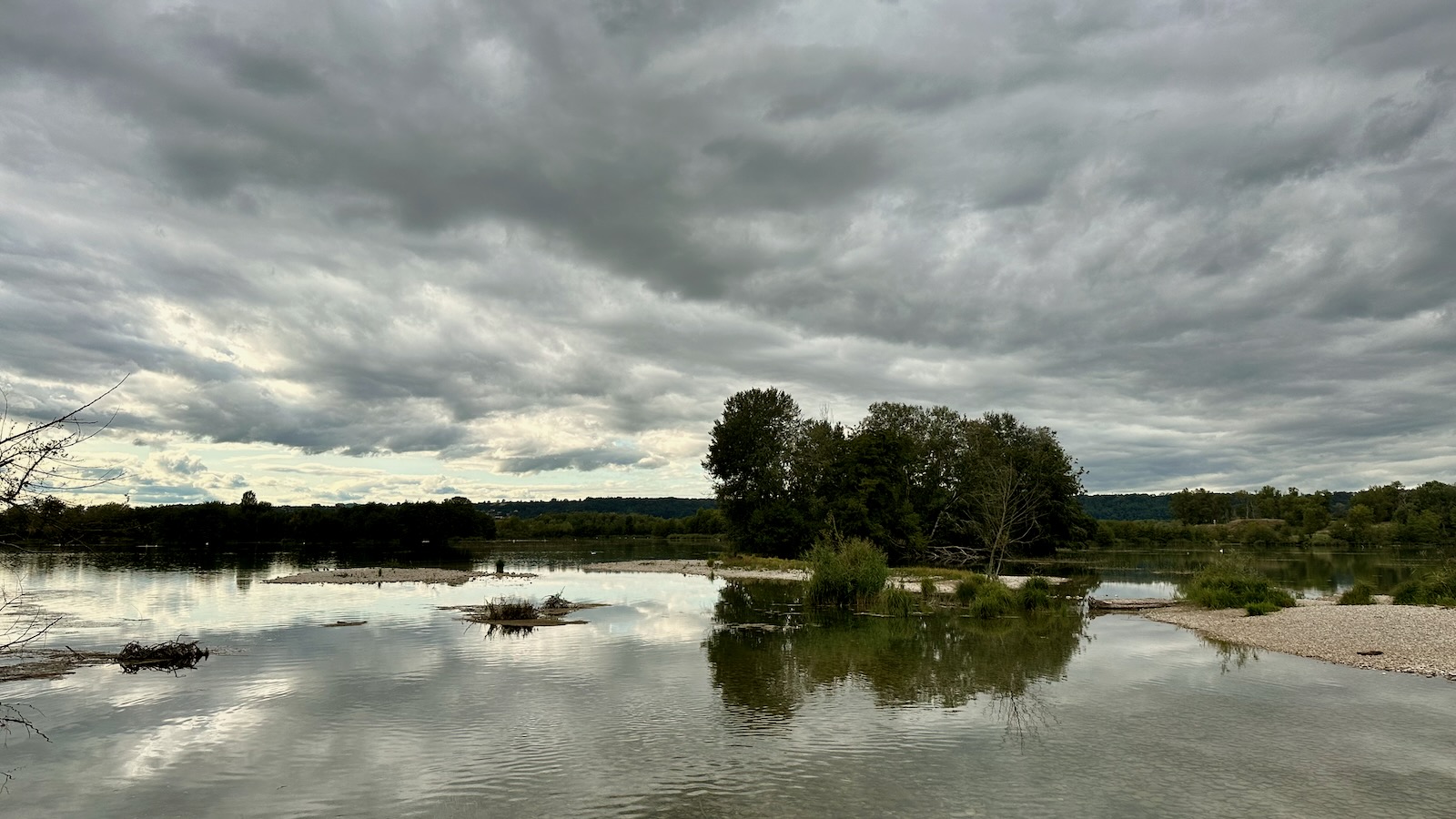 Sous le ciel gris et les nuages l'eau transparente sur les galets.